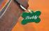 Pet tag engraving with rotary engraving machine on green anodized aluminum tag attached to leather collar